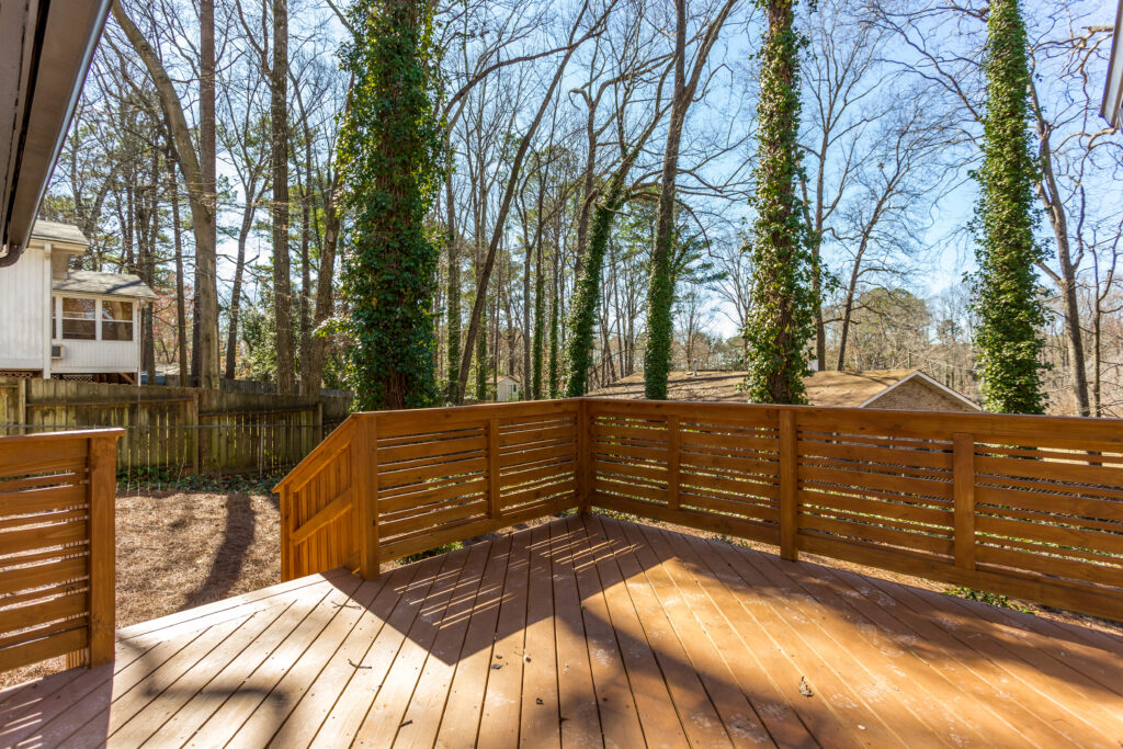 Newly built wooden deck featuring surrounding mature trees, deck addition by Parsons Mission Construction