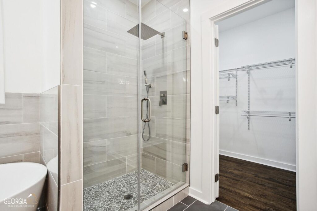 Glass-enclosed shower featuring floor-to-ceiling tile surround and frameless glass doors, bathroom remodeling by Parsons Mission Construction